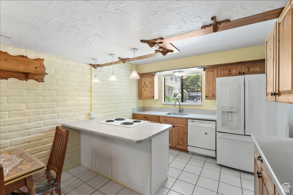 Kitchen featuring white appliances, a sink, light countertops, light tile patterned floors, and a textured ceiling