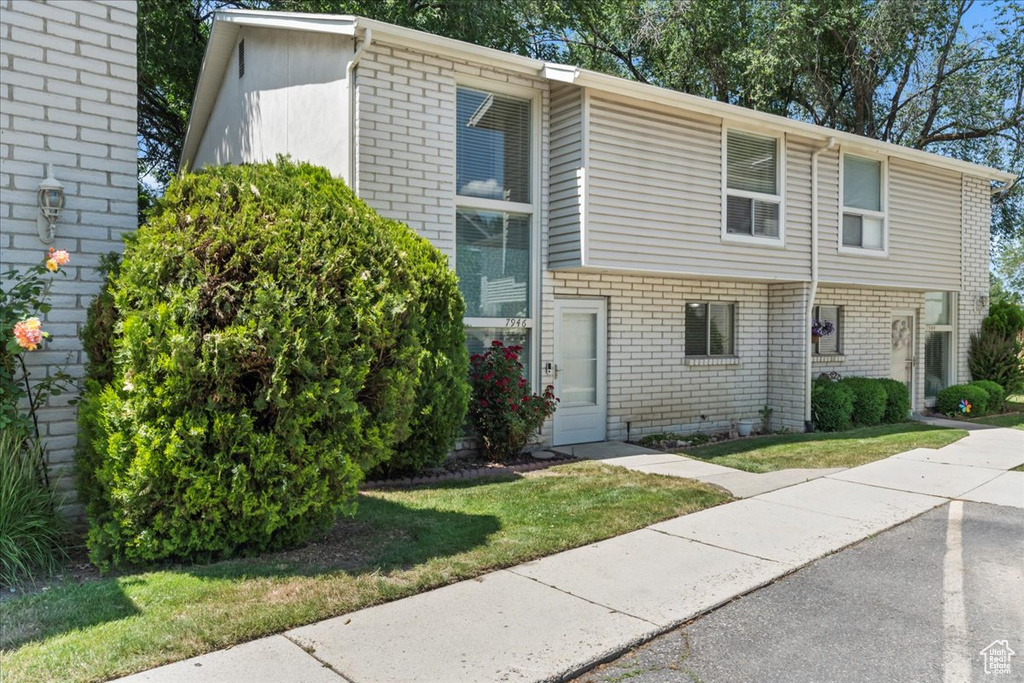 View of front facade with brick siding and a front lawn