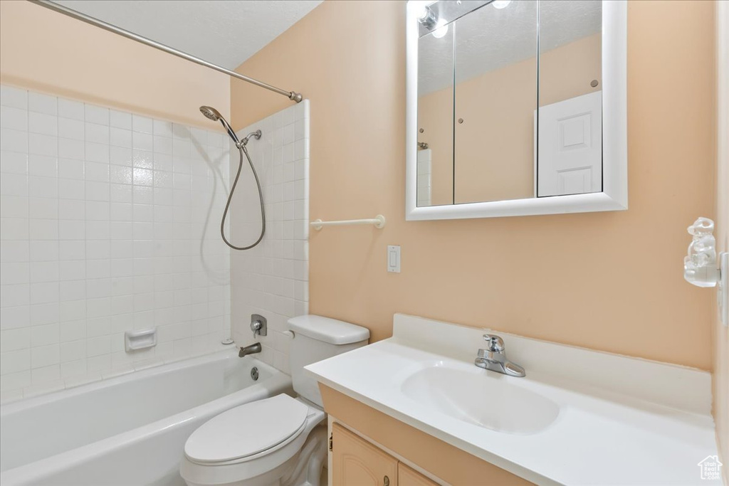 Full bath featuring toilet, vanity, and shower / bathtub combination