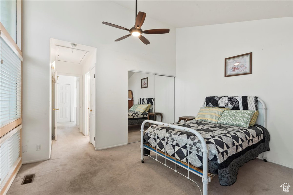 Bedroom featuring attic access, carpet, a closet, high vaulted ceiling, and a ceiling fan