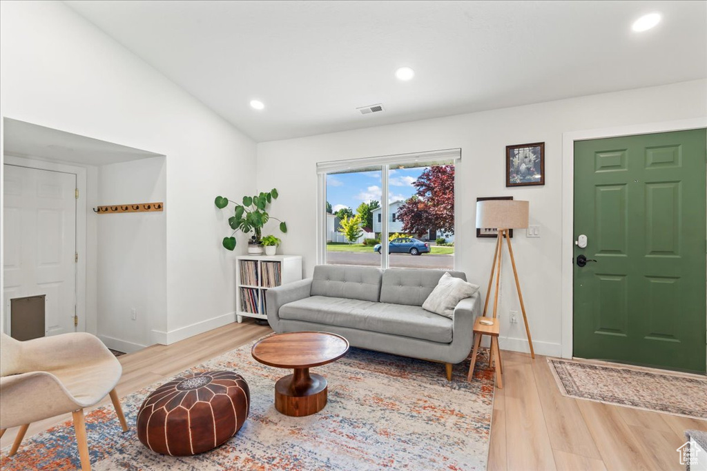 Living area featuring light wood-style floors, baseboards, recessed lighting, and lofted ceiling
