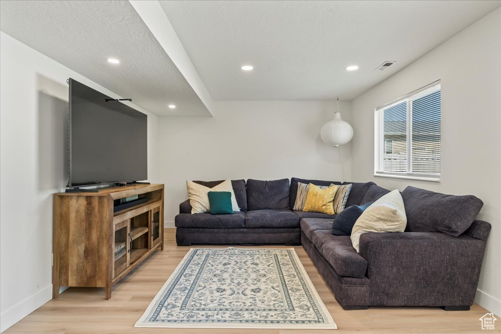 Living area with light wood-style flooring, recessed lighting, and baseboards
