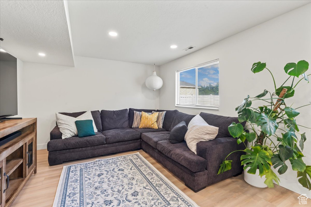 Living area featuring light wood-style floors and recessed lighting