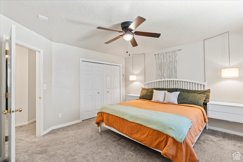 Bedroom featuring carpet flooring, a closet, baseboards, ceiling fan, and a textured ceiling