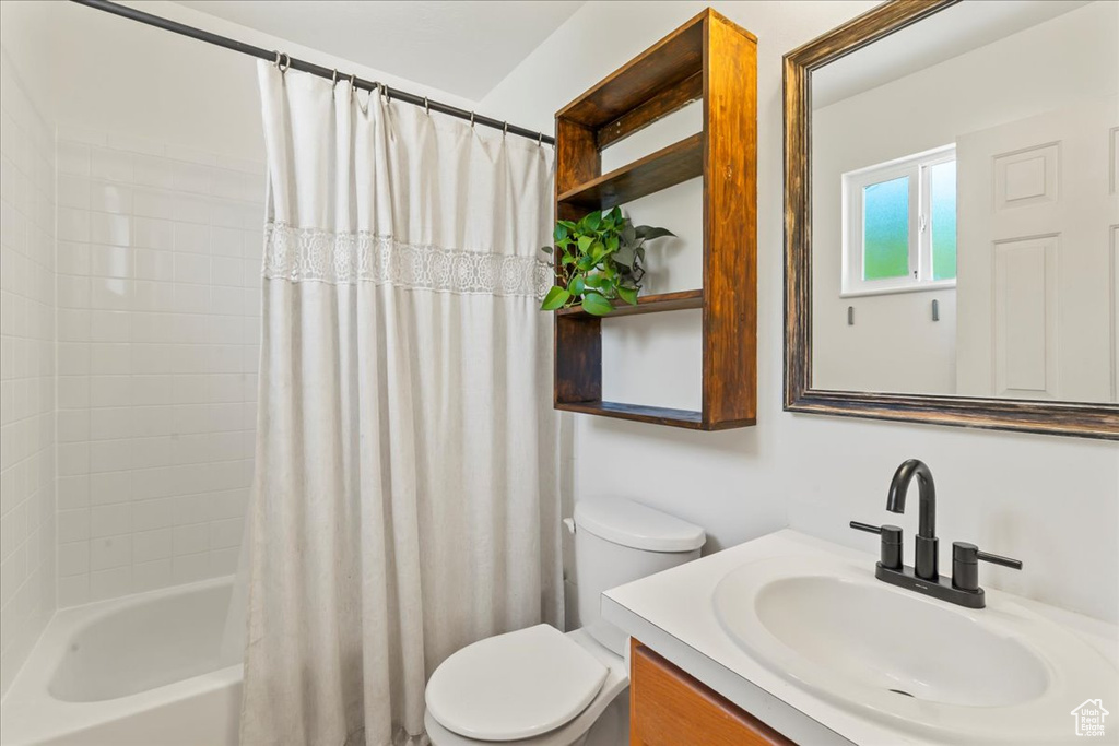 Full bathroom featuring vanity, toilet, and shower / bath combo with shower curtain