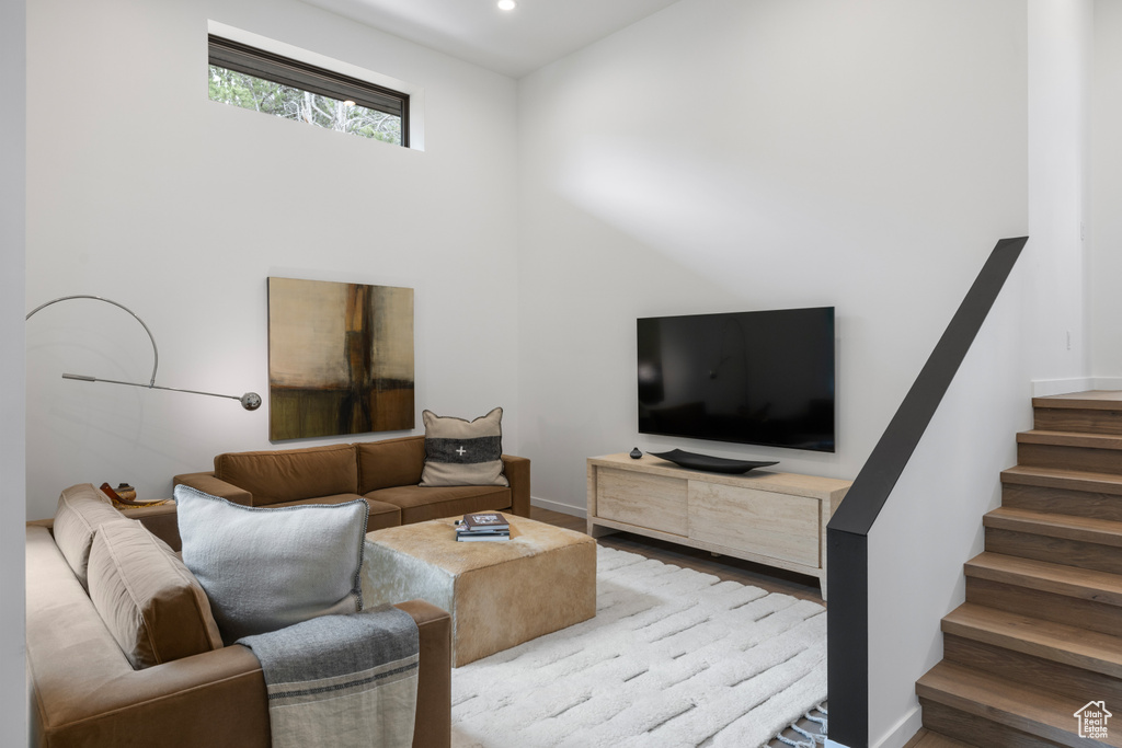 Living area with stairway, recessed lighting, baseboards, and wood finished floors