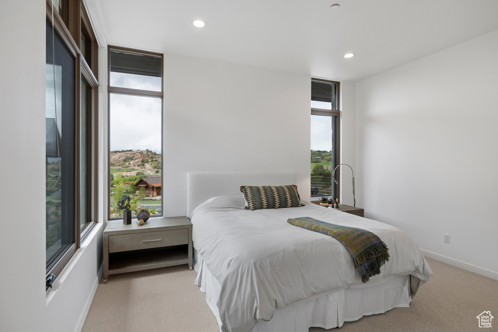 Carpeted bedroom with floor to ceiling windows, recessed lighting, and baseboards