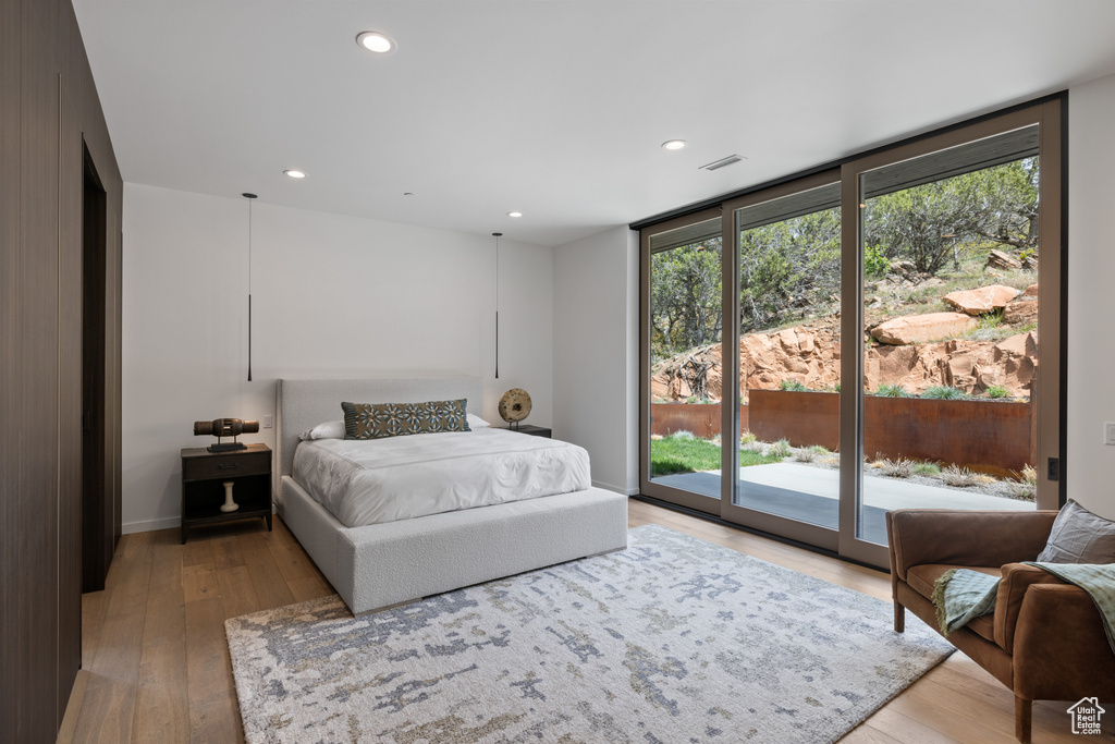 Bedroom with access to outside, light wood-style floors, and recessed lighting