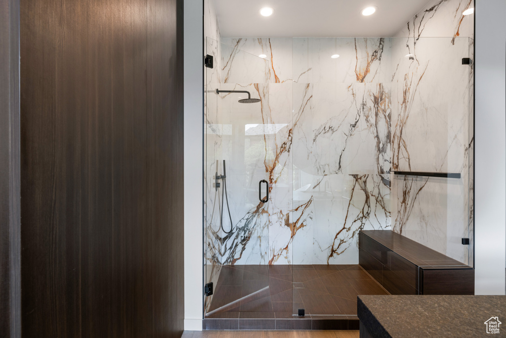 Full bath with a marble finish shower and recessed lighting