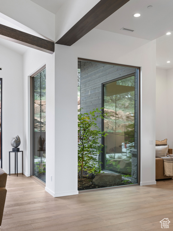 Doorway featuring wood finished floors, healthy amount of natural light, recessed lighting, and baseboards