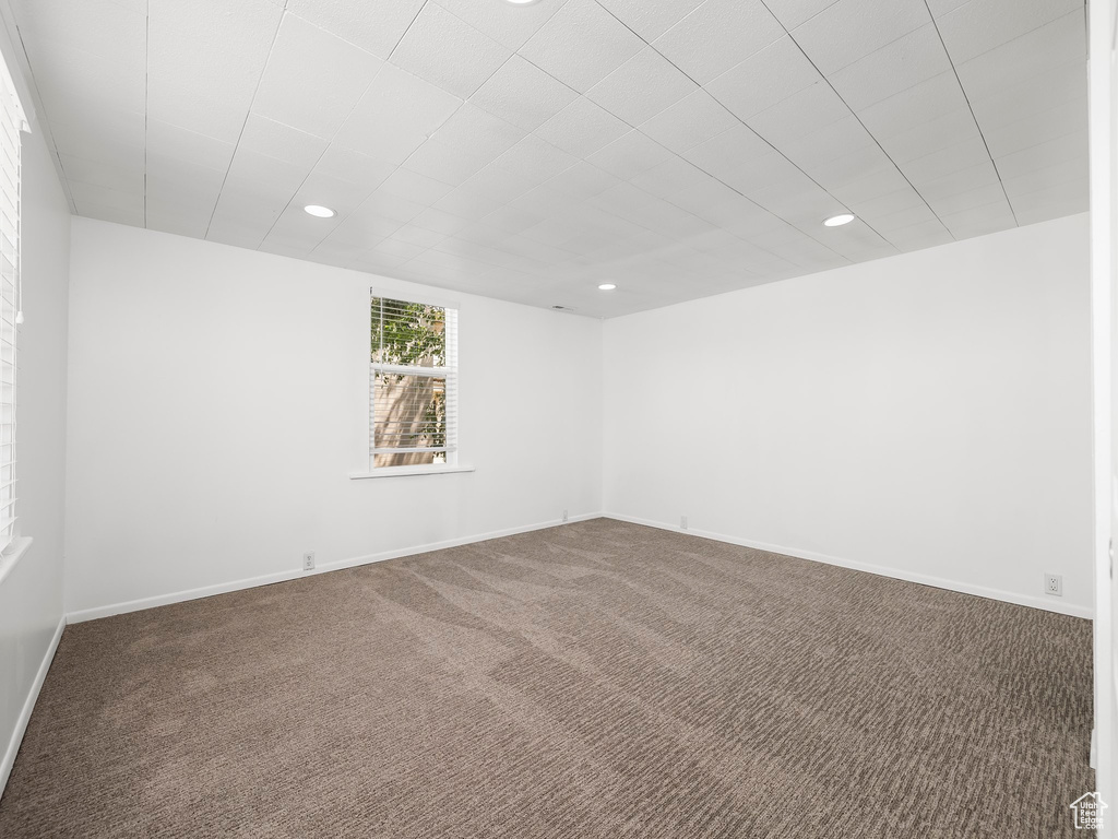 Carpeted empty room featuring recessed lighting and baseboards