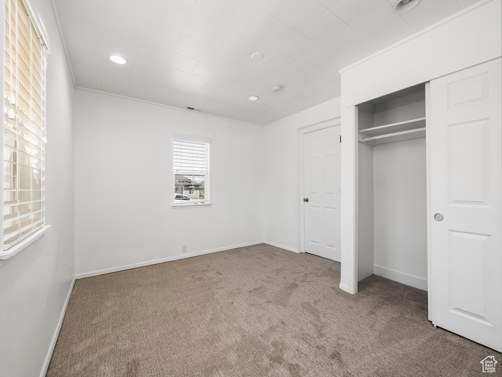Unfurnished bedroom featuring carpet floors, recessed lighting, baseboards, and a closet