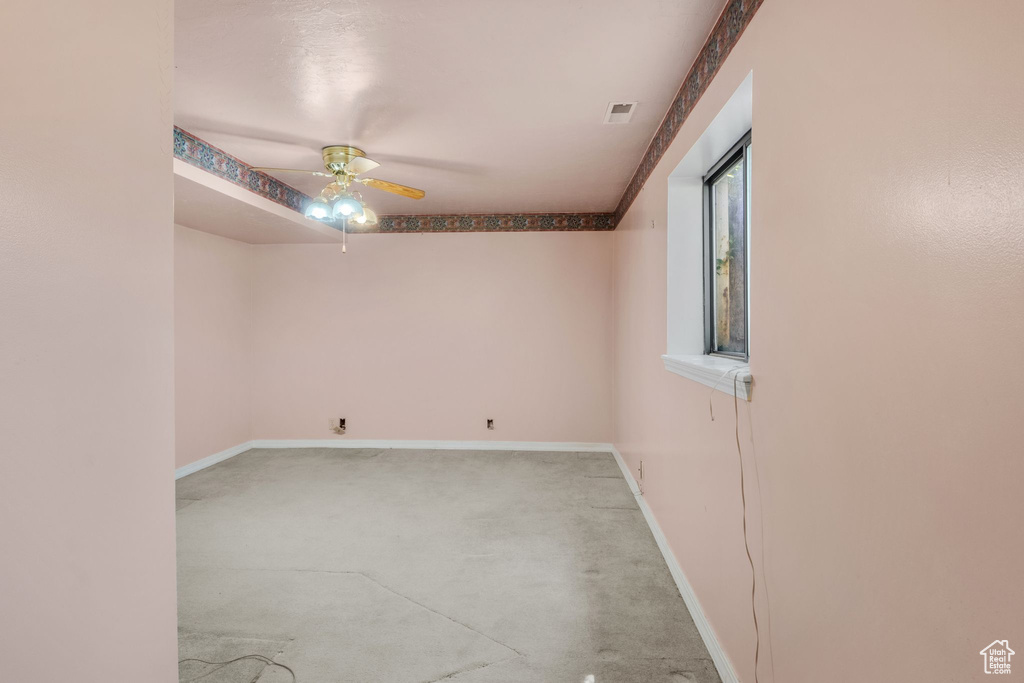 Spare room with ceiling fan, light colored carpet, and baseboards