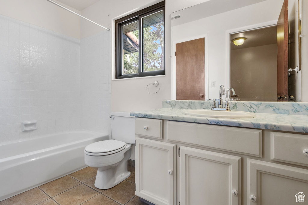 Full bathroom with vanity, tile patterned flooring, toilet, and washtub / shower combination