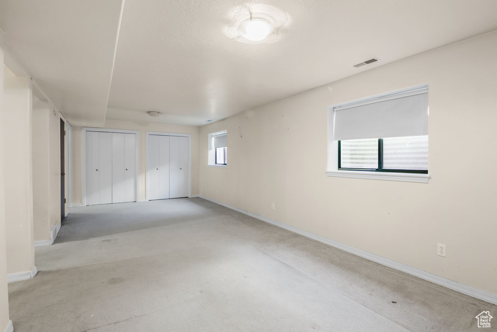 Unfurnished bedroom with multiple closets, baseboards, and carpet