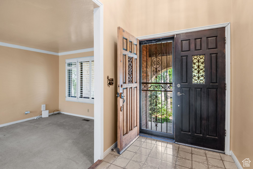 Foyer featuring healthy amount of natural light, baseboards, and crown molding