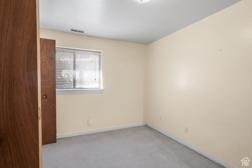 Empty room with light carpet and baseboards