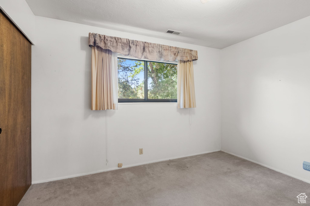 Carpeted empty room featuring baseboards