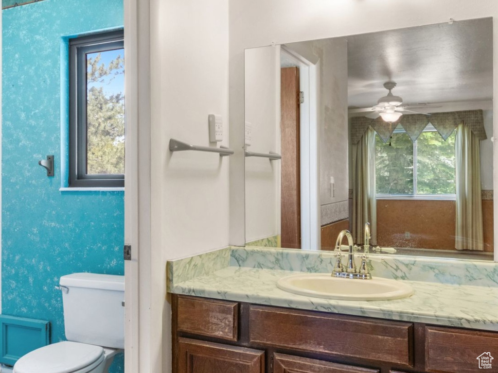 Bathroom with vanity, toilet, and ceiling fan