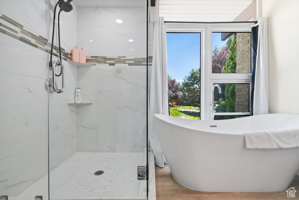 Full bathroom featuring a stall shower, healthy amount of natural light, and a freestanding tub