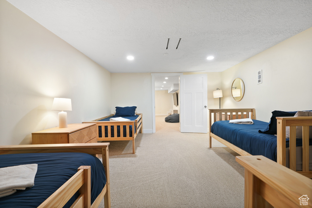 Bedroom featuring light carpet, recessed lighting, baseboards, and a textured ceiling