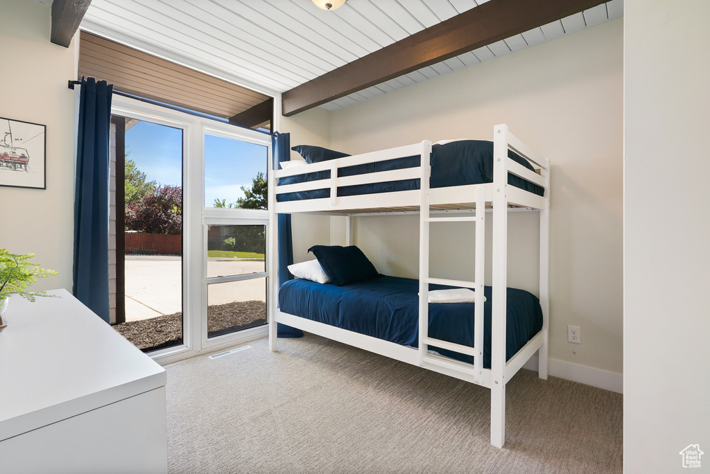 Carpeted bedroom with beam ceiling
