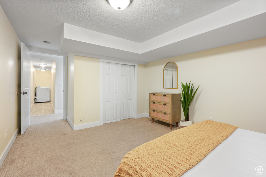 Bedroom featuring carpet floors, a closet, a textured ceiling, and baseboards