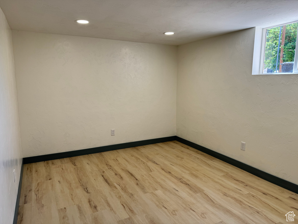 Empty room with wood finished floors, baseboards, and recessed lighting