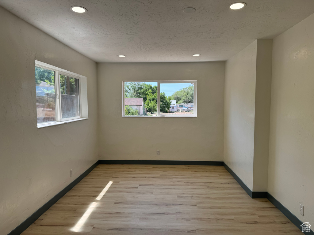 Unfurnished room featuring light wood-style floors, recessed lighting, and baseboards