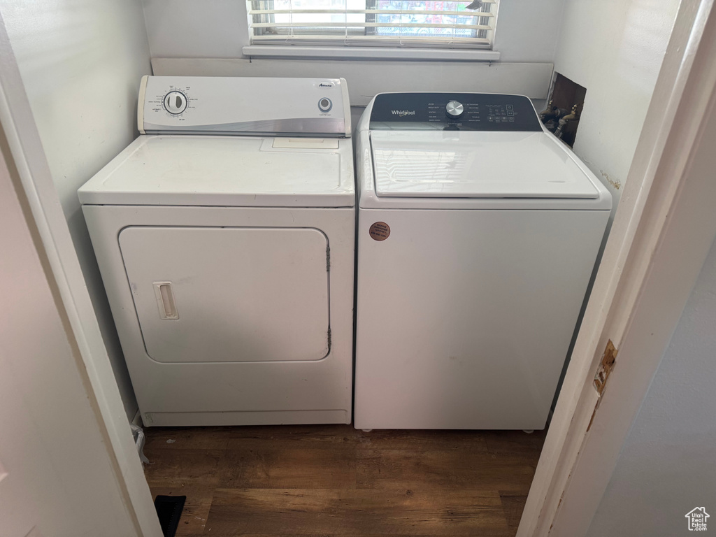 Washroom with washer and dryer and wood finished floors