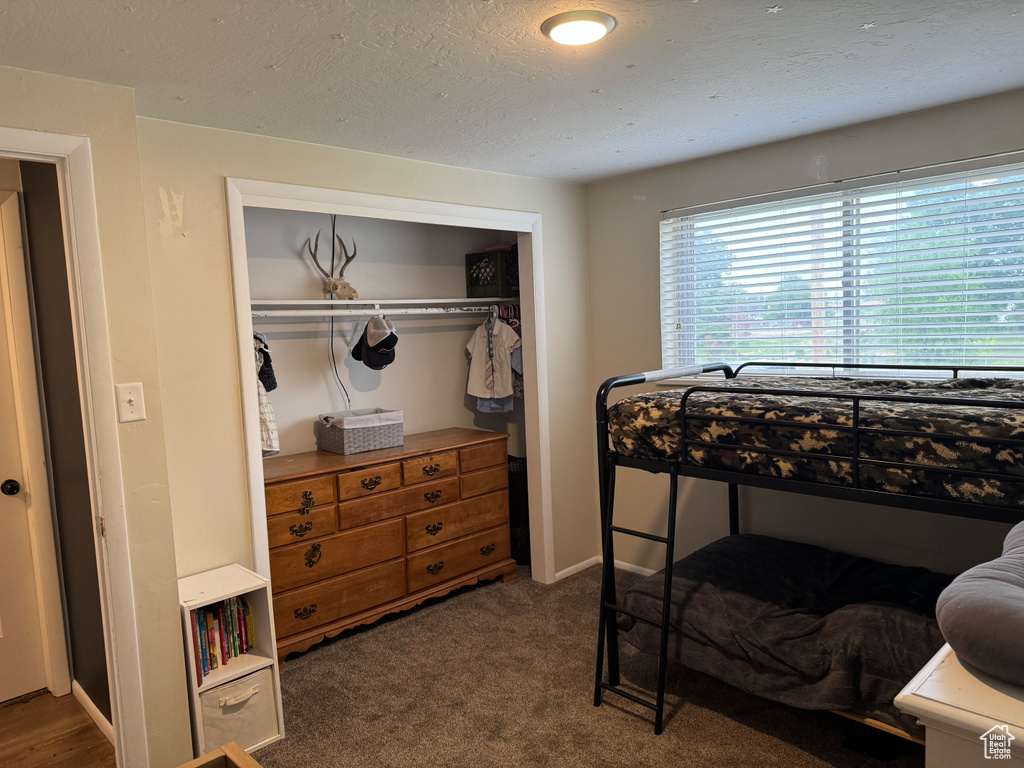 Bedroom featuring a closet, a textured ceiling, and carpet