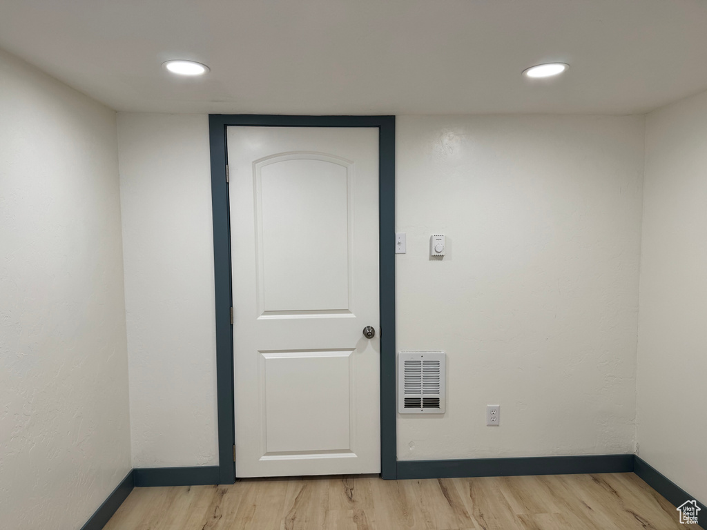 Spare room featuring light wood-style floors, baseboards, and recessed lighting