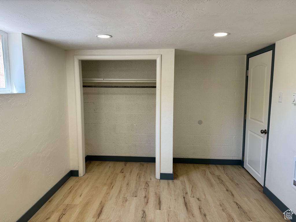 Unfurnished bedroom with light wood finished floors, baseboards, and a closet
