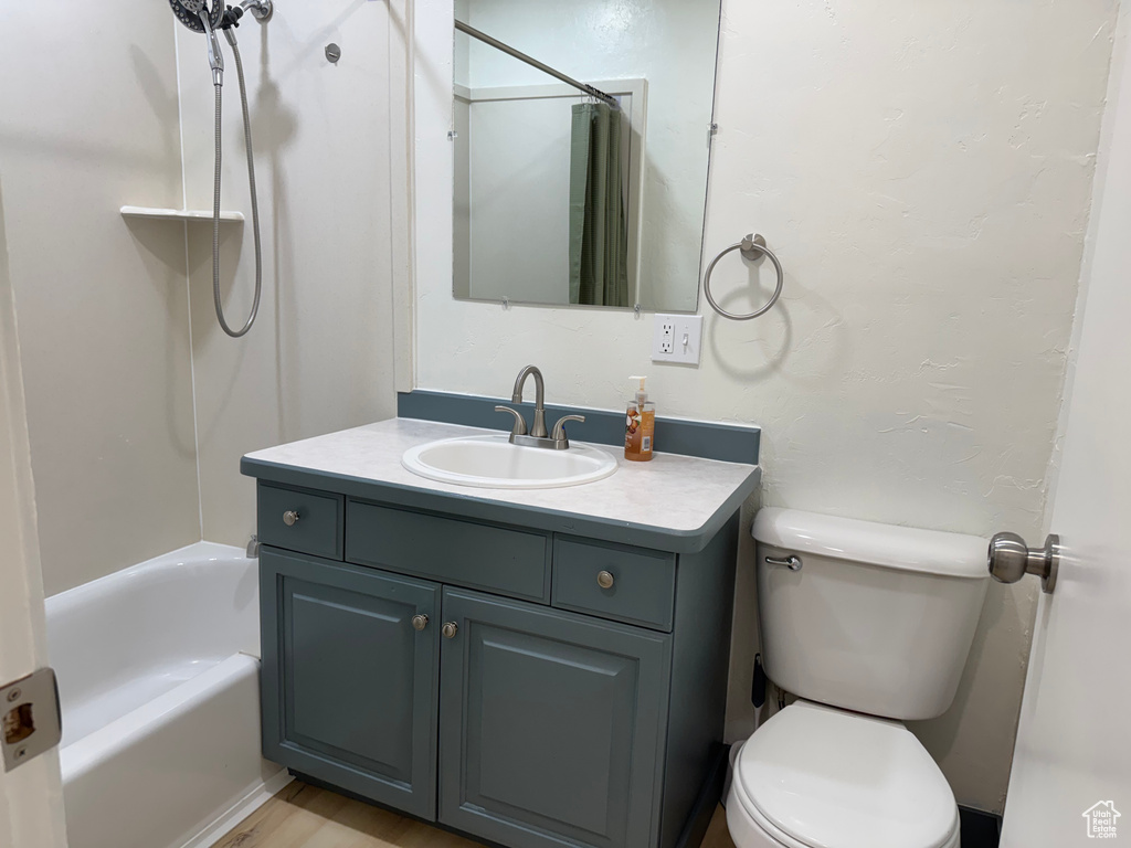 Bathroom with vanity, toilet, and shower / tub combo with curtain