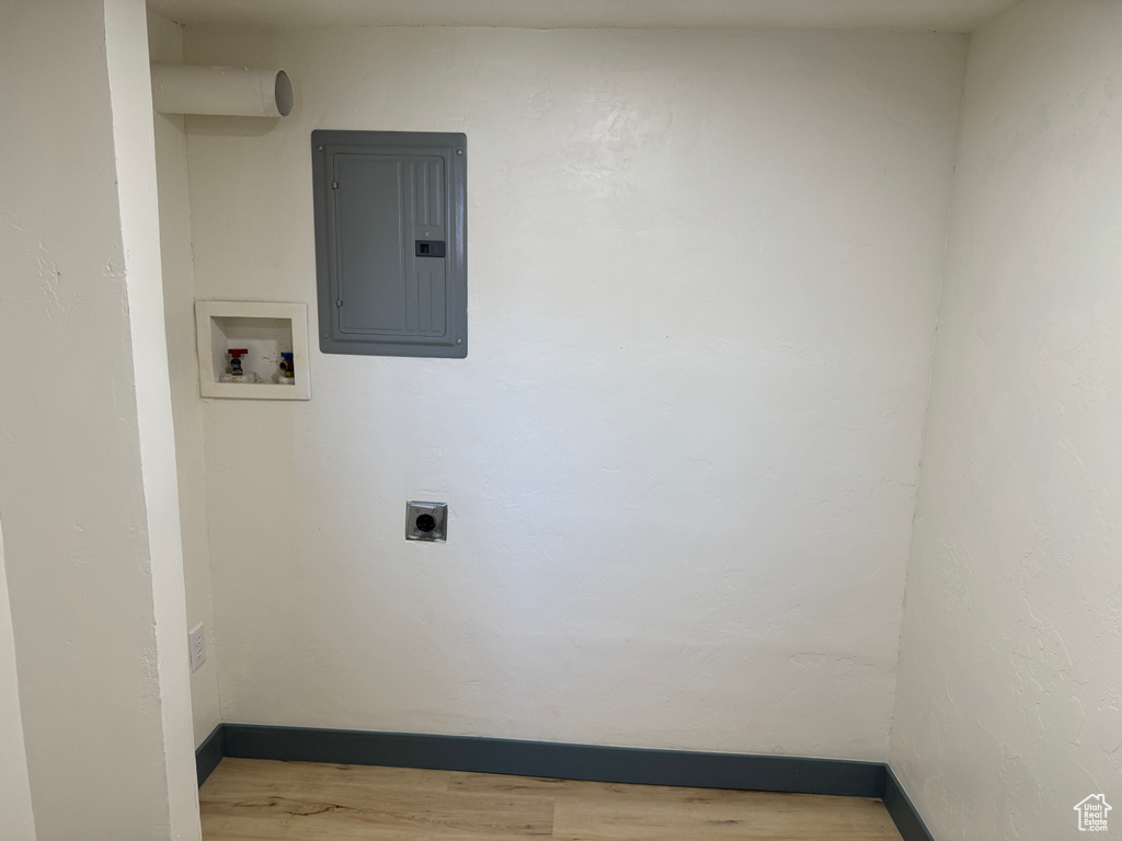 Washroom featuring electric panel, wood finished floors, hookup for a washing machine, hookup for an electric dryer, and baseboards