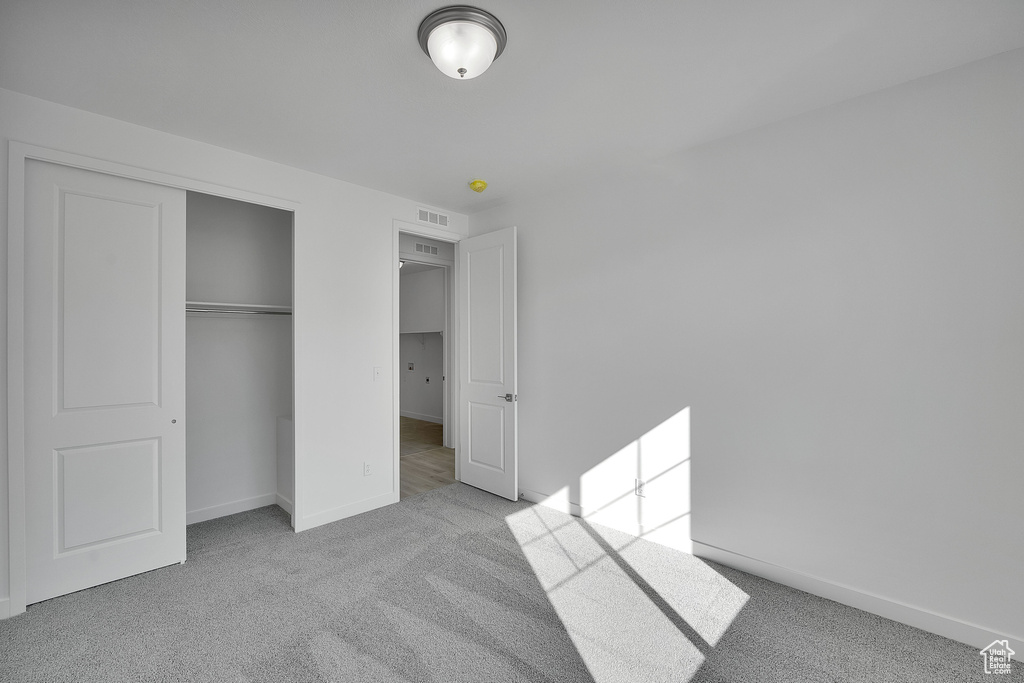 Unfurnished bedroom with carpet flooring, baseboards, and a closet