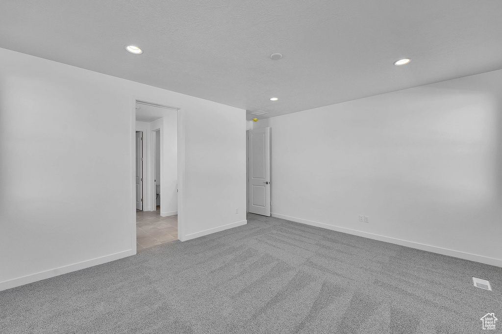 Spare room featuring carpet flooring, recessed lighting, and baseboards