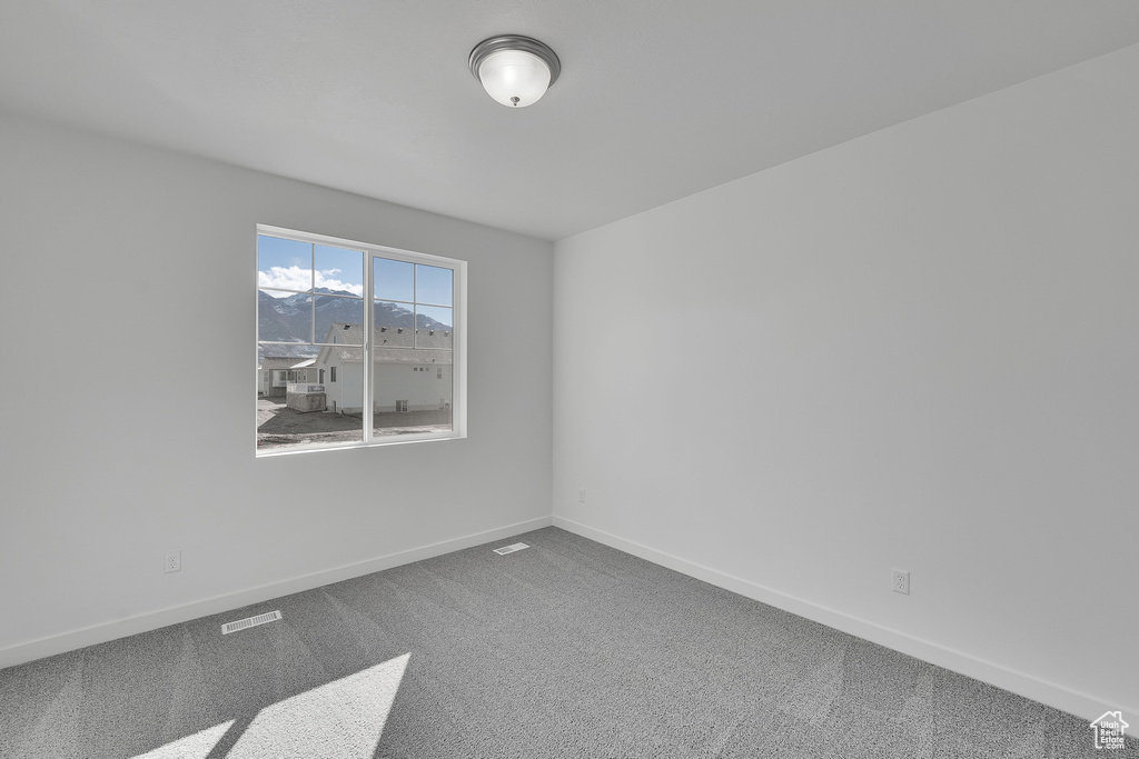 Empty room with carpet and baseboards