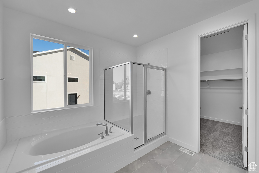 Full bath with a garden tub, a shower stall, a walk in closet, recessed lighting, and tile patterned flooring