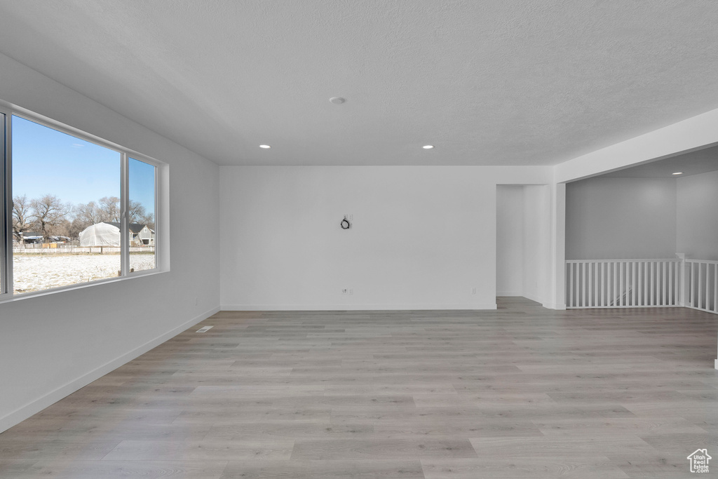 Empty room featuring recessed lighting, light wood-style flooring, and baseboards