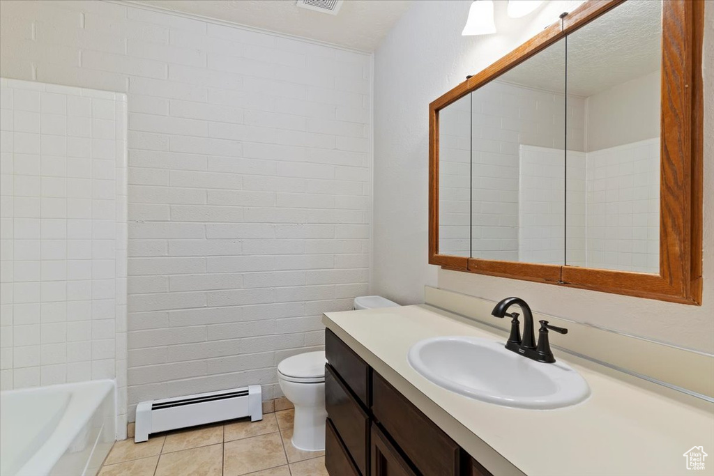 Bathroom featuring baseboard heating, tile patterned floors, toilet, and vanity