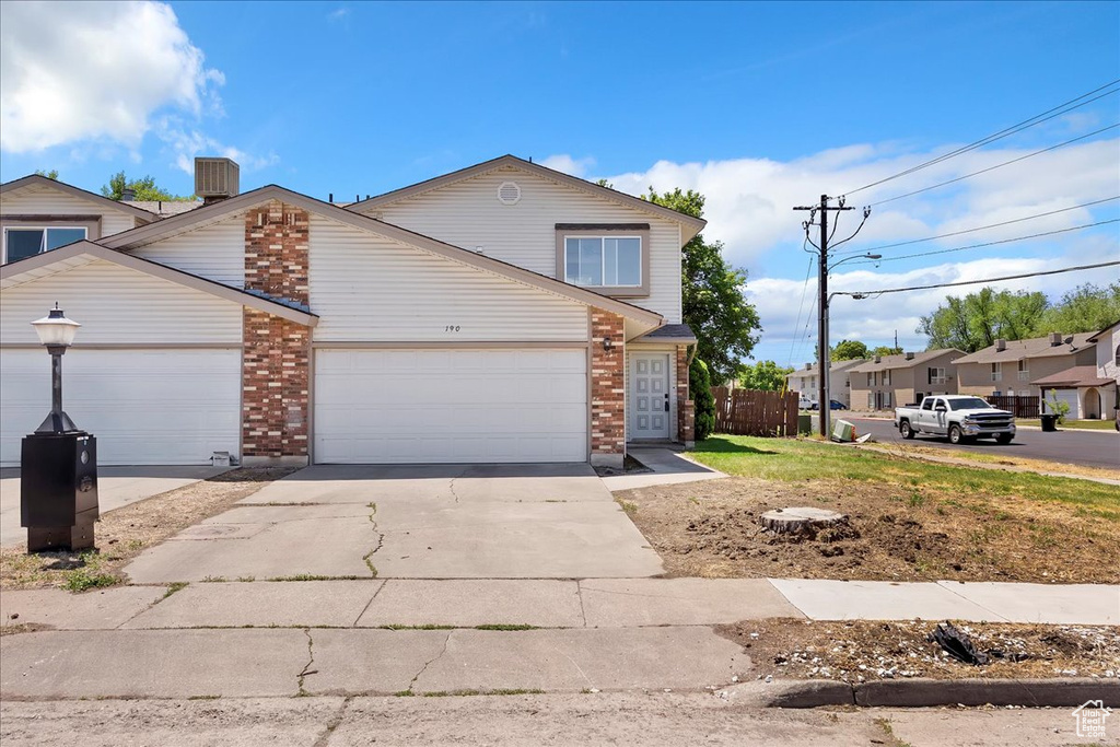 Traditional-style home featuring brick siding, concrete driveway, an attached garage, and central air condition unit