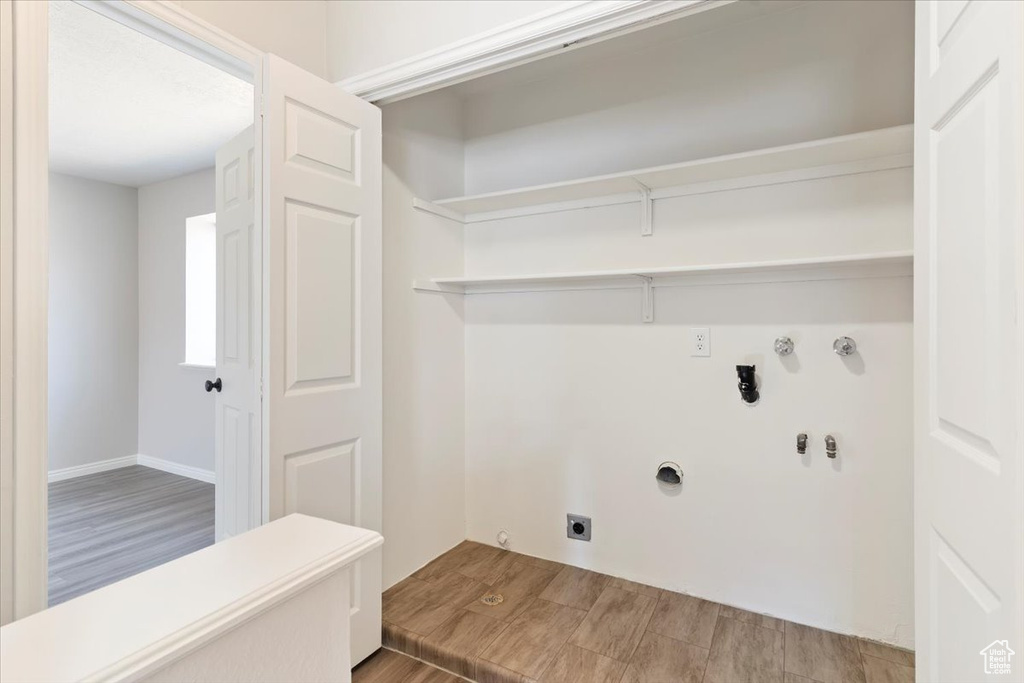 Washroom with electric dryer hookup, gas dryer hookup, wood finished floors, and hookup for a washing machine