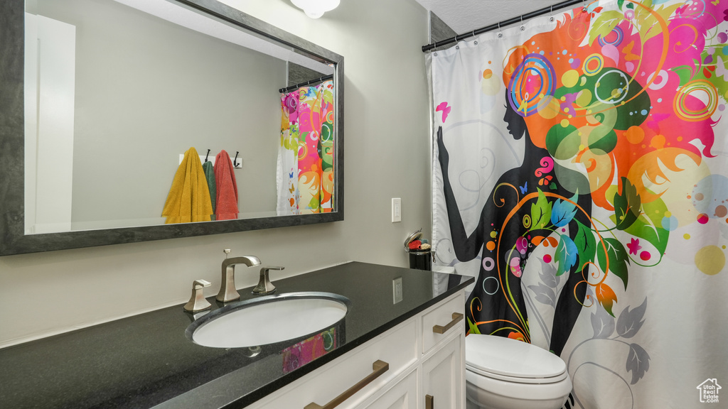 Full bath with vanity, toilet, and a shower with curtain