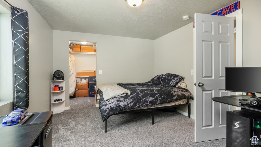 Carpeted bedroom with a textured ceiling and baseboards