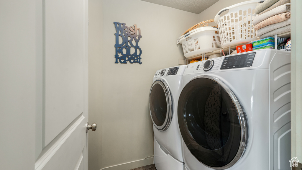 Washroom featuring separate washer and dryer and baseboards