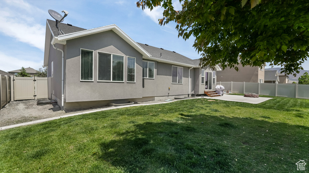 Back of house featuring a patio area, a gate, and stucco siding