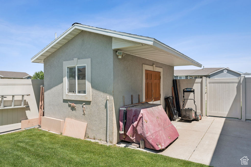 Rear view of property with stucco siding and a gate