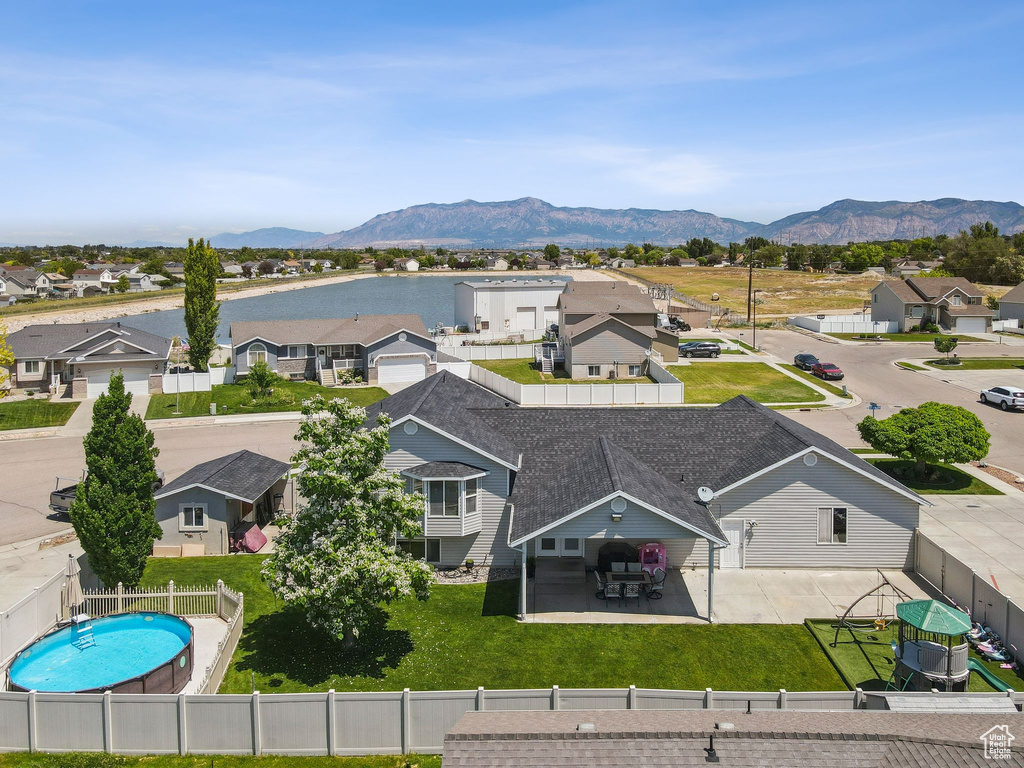 Aerial perspective of suburban area with a mountain backdrop and a pool area