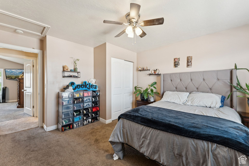 Carpeted bedroom featuring ceiling fan and baseboards